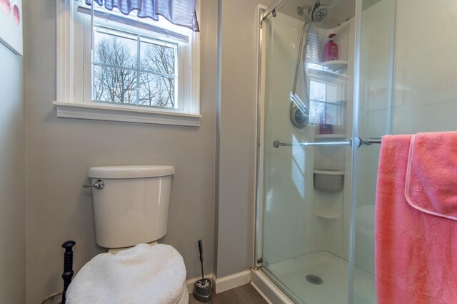 bathroom featuring walk in shower and toilet