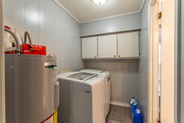 laundry area featuring washing machine and clothes dryer, cabinets, a textured ceiling, electric water heater, and hardwood / wood-style flooring