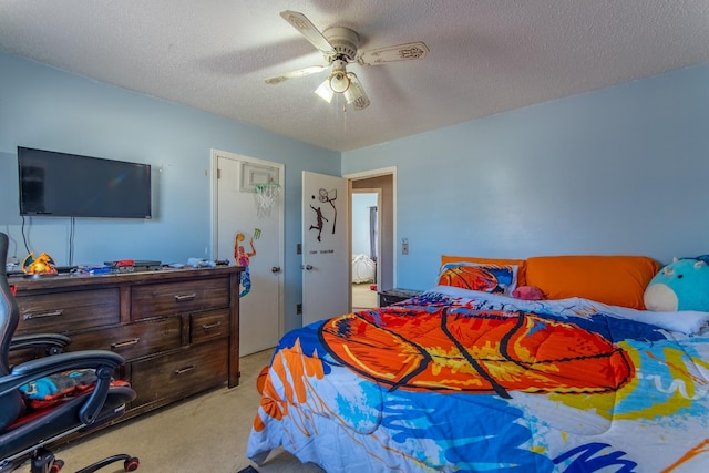 carpeted bedroom featuring a textured ceiling and ceiling fan