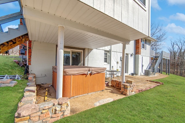 exterior space featuring a hot tub, central AC unit, a patio, and a lawn