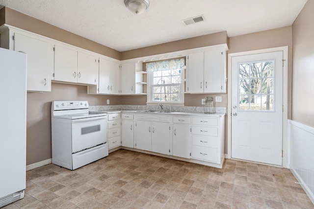 kitchen featuring white appliances, a wealth of natural light, sink, and white cabinets