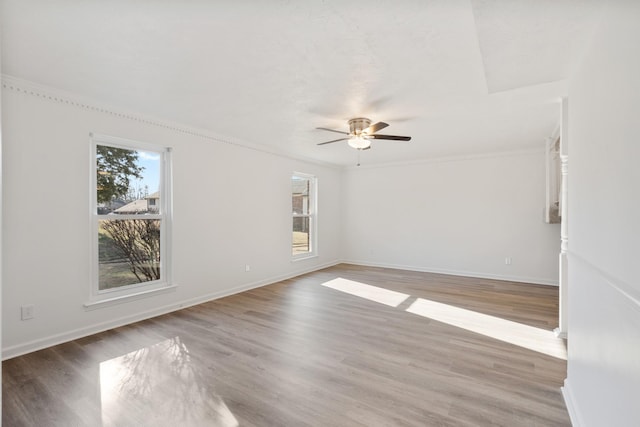 empty room featuring hardwood / wood-style floors, plenty of natural light, ornamental molding, and ceiling fan