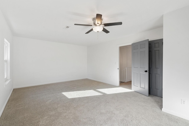 unfurnished room featuring light colored carpet and ceiling fan