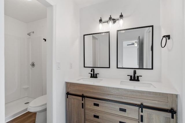 bathroom with walk in shower, vanity, toilet, and hardwood / wood-style floors