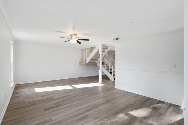 unfurnished living room featuring dark hardwood / wood-style flooring, crown molding, and ceiling fan