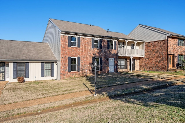 view of front of house with a balcony and a front yard