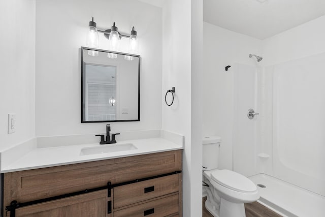 bathroom featuring vanity, toilet, and a shower