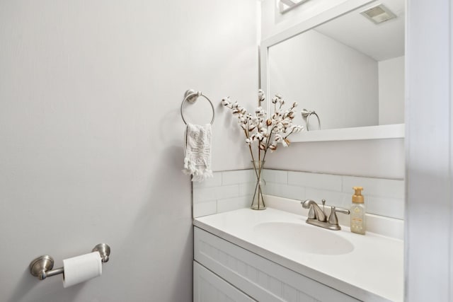 bathroom with tasteful backsplash and vanity