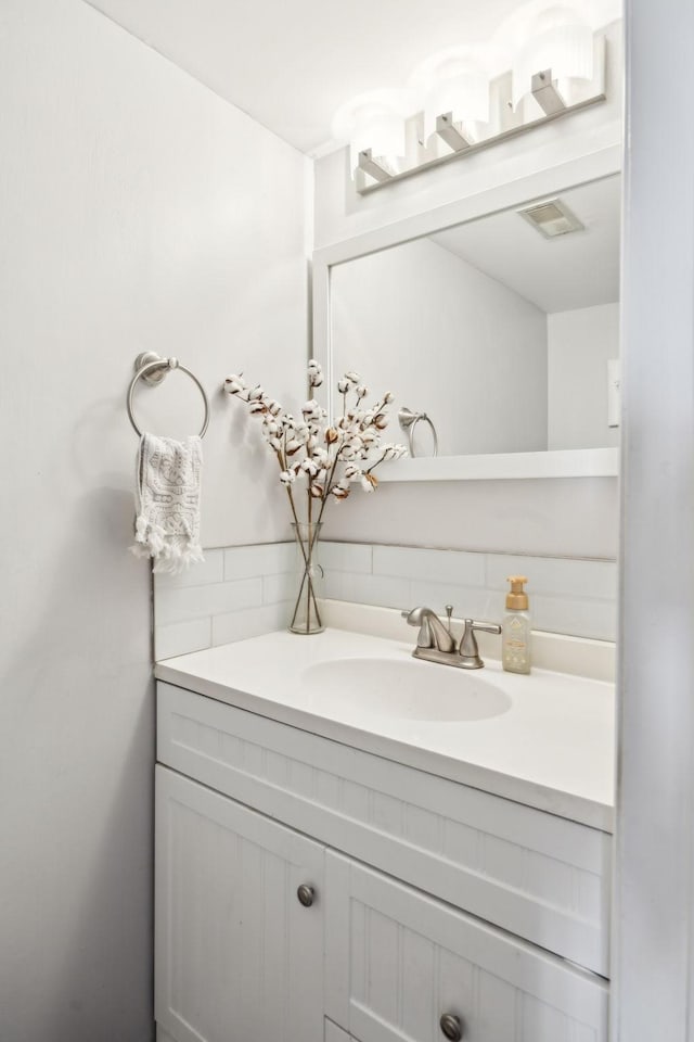 bathroom with vanity and decorative backsplash