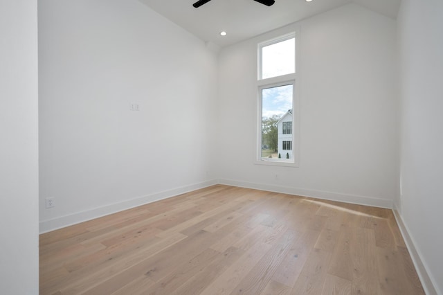 spare room with lofted ceiling, ceiling fan, and light hardwood / wood-style flooring