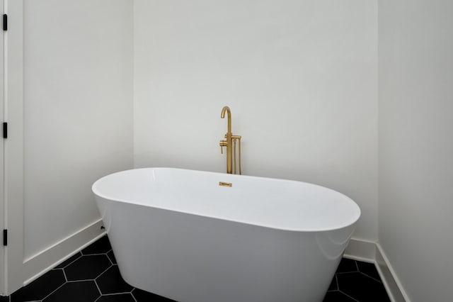 bathroom with a washtub and tile patterned floors