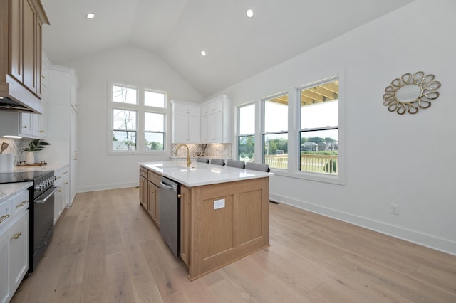 kitchen featuring white cabinetry, decorative backsplash, stainless steel appliances, and an island with sink