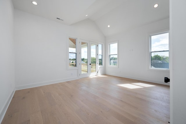 empty room with lofted ceiling, light hardwood / wood-style flooring, and french doors