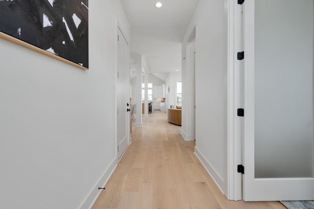 hallway with light hardwood / wood-style floors