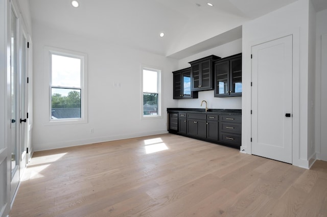 kitchen with plenty of natural light, sink, vaulted ceiling, and light wood-type flooring