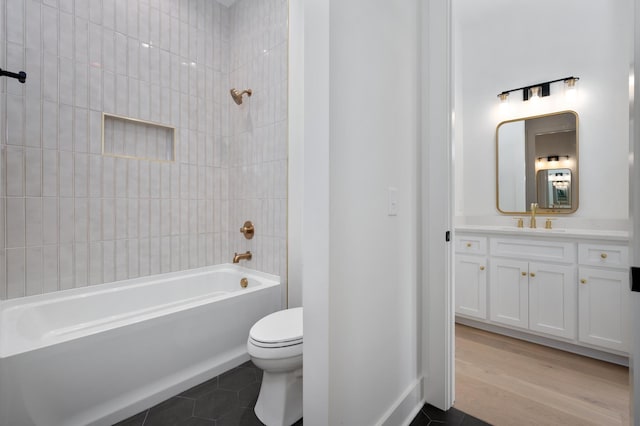 full bathroom with tiled shower / bath, vanity, toilet, and tile patterned flooring