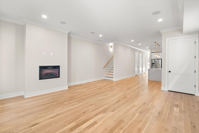 unfurnished living room featuring crown molding and light hardwood / wood-style flooring