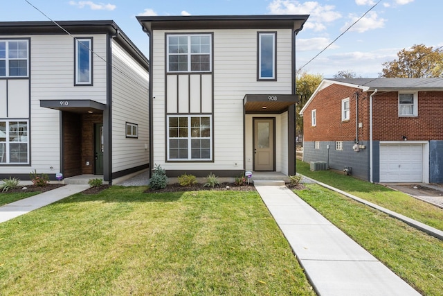 view of front of house with a garage, central AC, and a front lawn