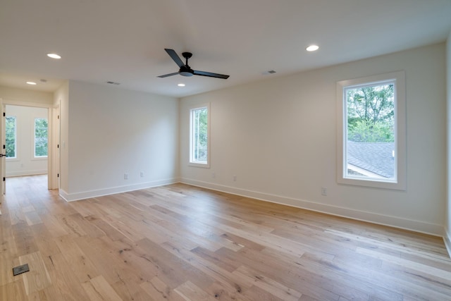 spare room with ceiling fan, plenty of natural light, and light wood-type flooring