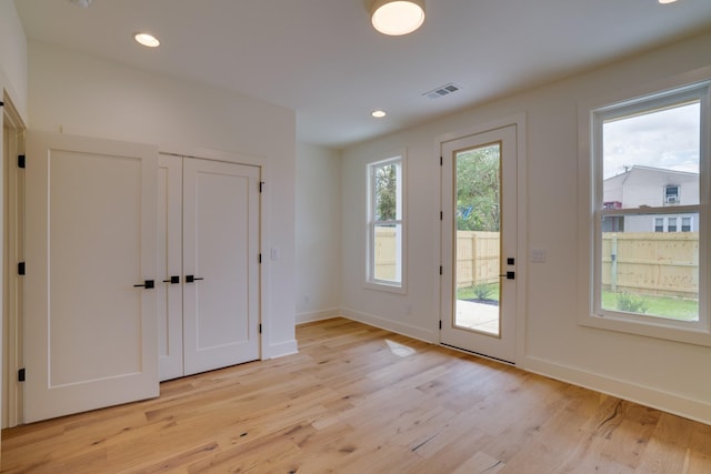 doorway with plenty of natural light and light hardwood / wood-style floors