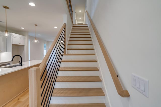 stairs with wood-type flooring and sink