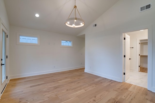 empty room with lofted ceiling and light hardwood / wood-style flooring