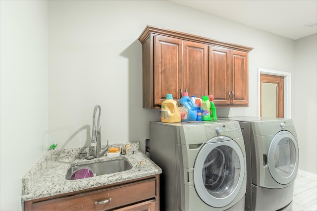 washroom with cabinets, separate washer and dryer, and sink