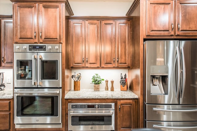 kitchen with light stone countertops and appliances with stainless steel finishes