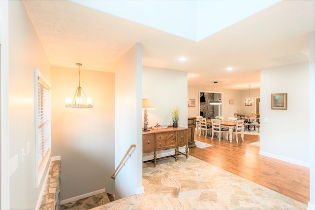 hallway featuring light hardwood / wood-style floors and a notable chandelier