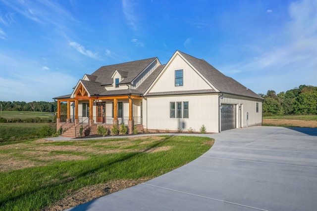 view of front of property featuring a garage, covered porch, and a front yard