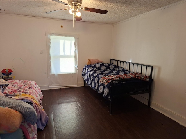 bedroom with ceiling fan, crown molding, dark wood-type flooring, and a textured ceiling