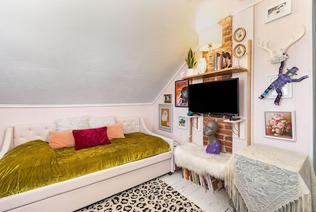 bedroom with lofted ceiling and a textured ceiling