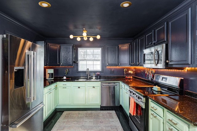 kitchen with sink, dark stone countertops, green cabinetry, stainless steel appliances, and crown molding