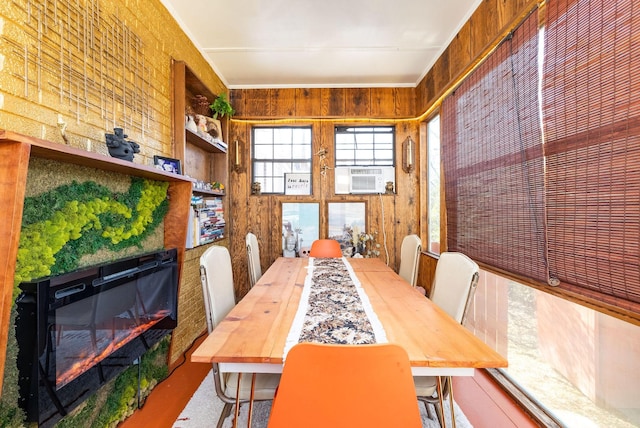 dining space featuring wooden walls, cooling unit, and a fireplace