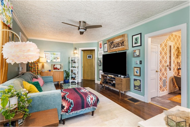 living room featuring crown molding, dark wood-type flooring, a textured ceiling, and ceiling fan