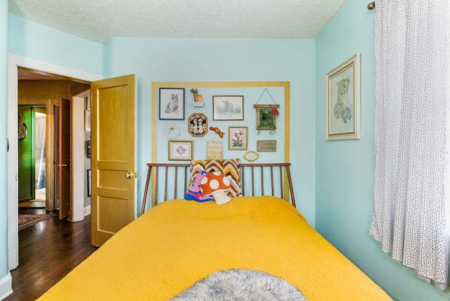 bedroom with dark wood-type flooring and a textured ceiling