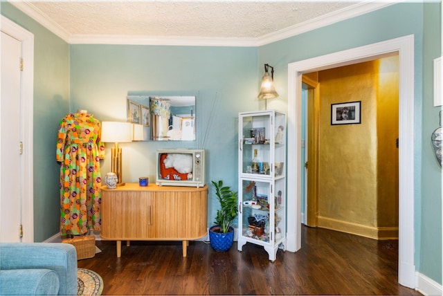 living area with dark hardwood / wood-style flooring, ornamental molding, and a textured ceiling