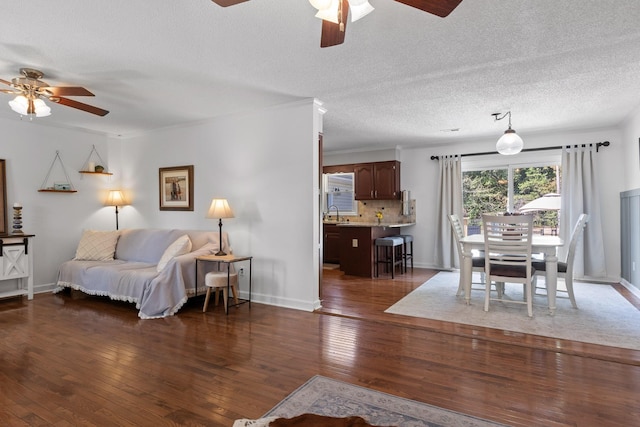 living room featuring ceiling fan, a textured ceiling, and dark hardwood / wood-style flooring