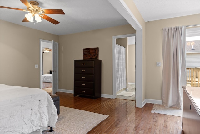 bedroom with connected bathroom, hardwood / wood-style floors, and ceiling fan