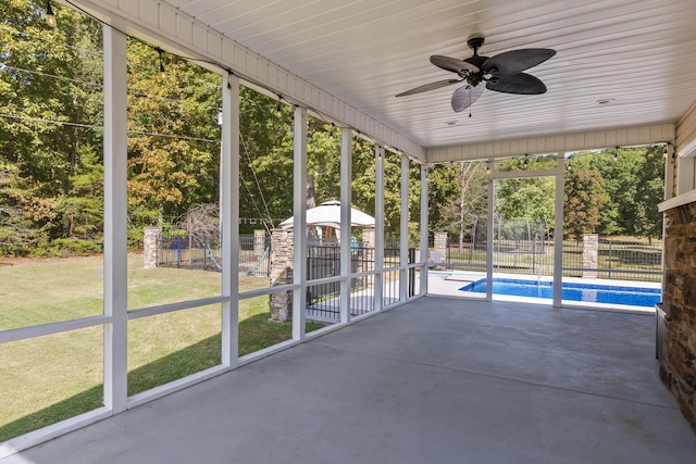 unfurnished sunroom featuring ceiling fan and a wealth of natural light