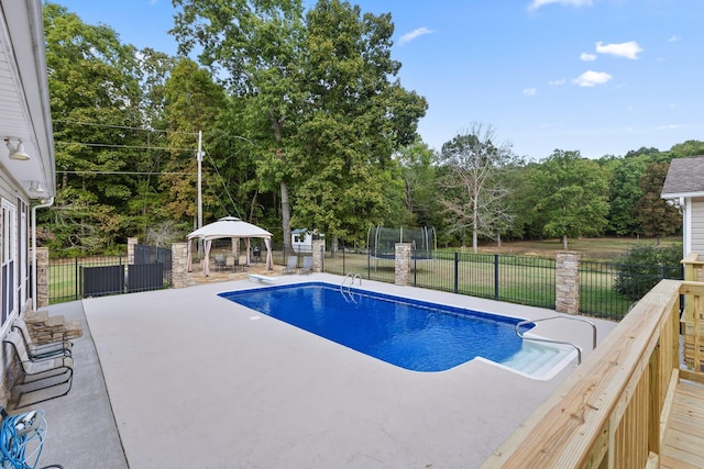 view of swimming pool with a gazebo, a diving board, a trampoline, and a patio area