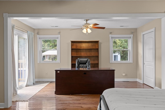 bedroom featuring ceiling fan, multiple windows, access to exterior, and light hardwood / wood-style flooring