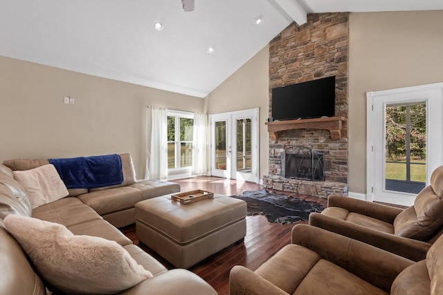 living room with beamed ceiling, a stone fireplace, plenty of natural light, and high vaulted ceiling