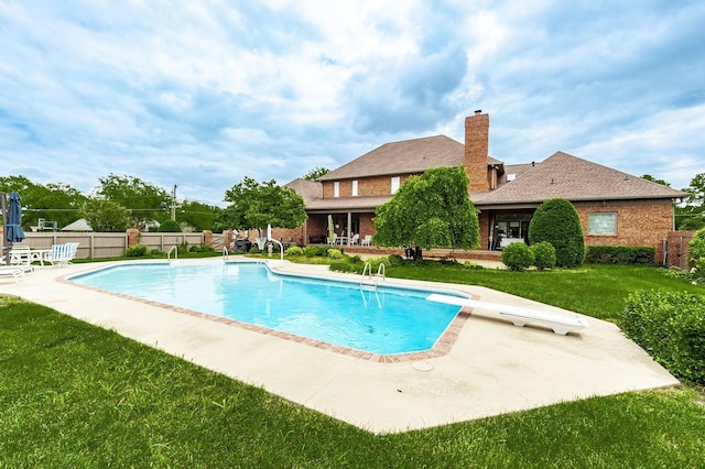 view of pool featuring a patio, a diving board, and a lawn