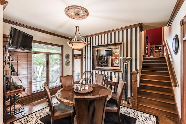 dining space with hardwood / wood-style floors and crown molding