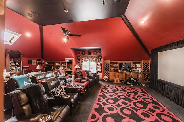 carpeted home theater featuring ceiling fan and vaulted ceiling with skylight