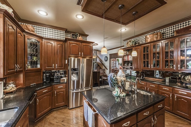 kitchen featuring hanging light fixtures, appliances with stainless steel finishes, sink, and light wood-type flooring