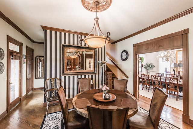 dining space featuring crown molding, an inviting chandelier, and dark hardwood / wood-style flooring