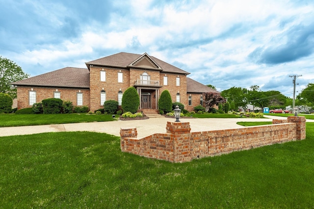 view of front of house with a balcony and a front lawn