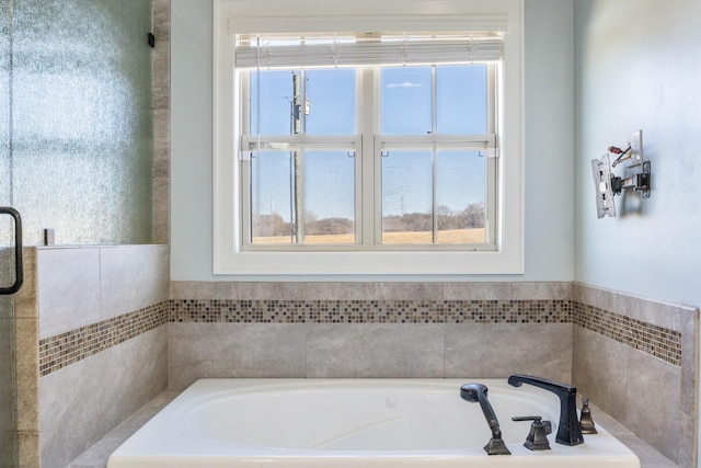 bathroom with plenty of natural light and a bath